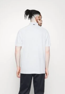 Lacoste X Netflix - Polo - White -Tenues Mode Boutique 7c890ee75e5b40a2884e01b3045865ca